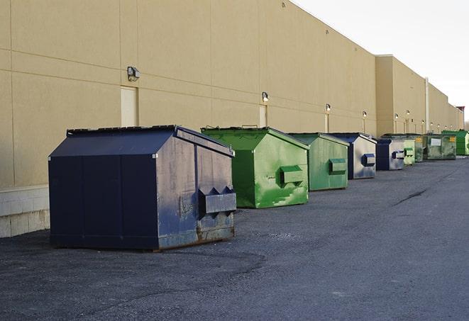 construction workers throw waste into a dumpster behind a building in Barlow, KY